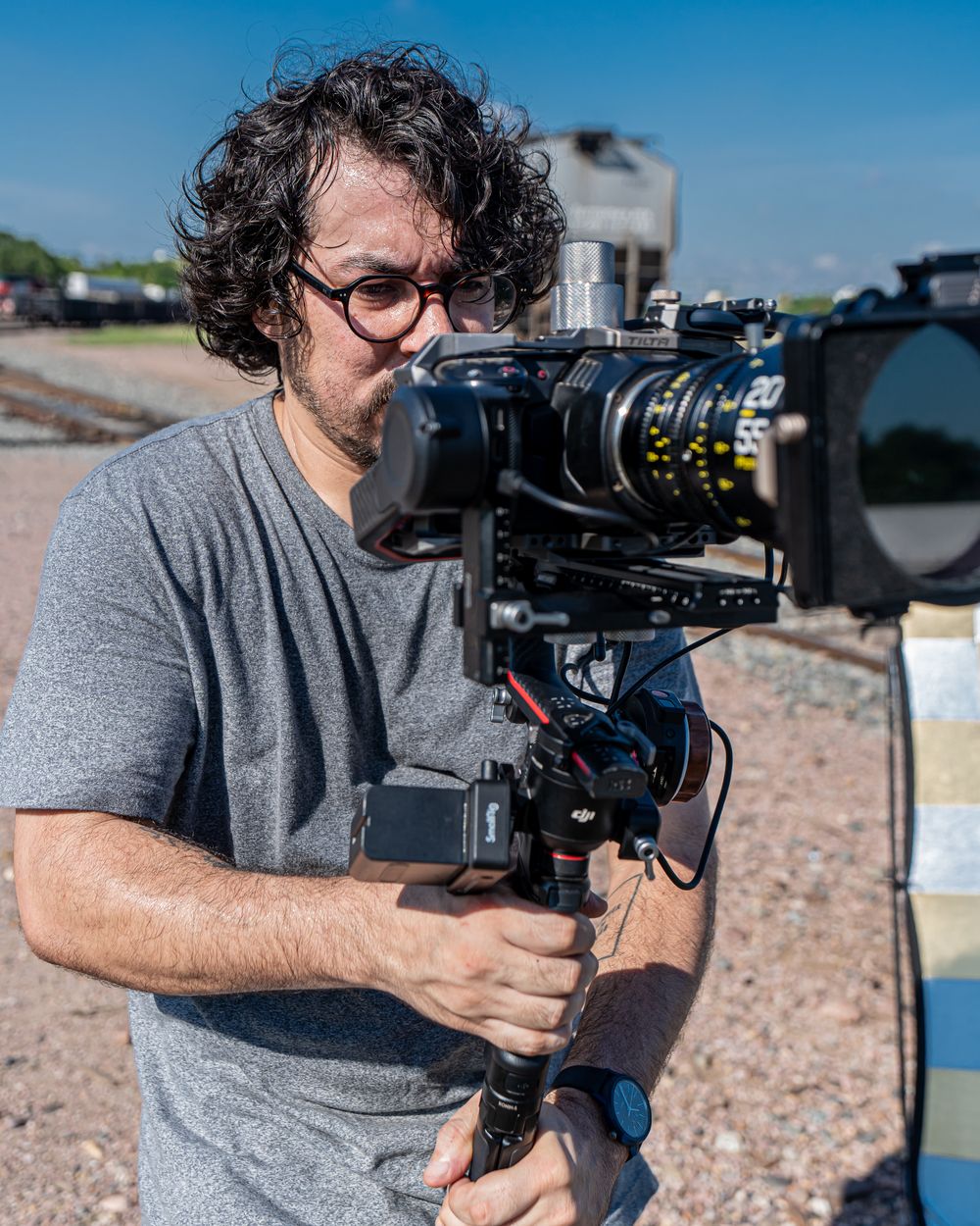 Hiram Manjarrez operando una cámara con gimbal bajo el sol, con un reflector detrás