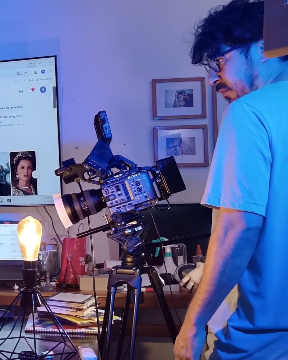 Cámara Sony en trípode en un set interior con luz azul y morada, y un integrante del equipo junto a ella